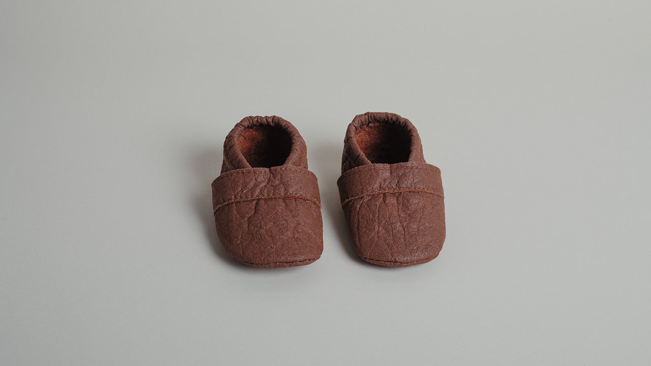 Stilvolle Krabbelschuhe in Zimtbraun aus Piñatex - perfekt für kleine Entdecker.