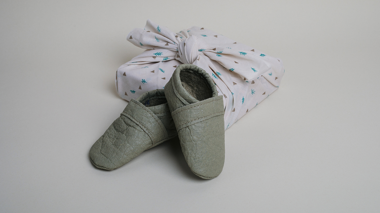 Das perfekte Geschenk: Krabbelschuhe in Salbeigrün aus Piñatex - stilvoll verpackt.